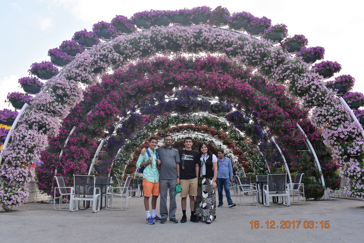 Family standing under a giant pink and purple flower arch