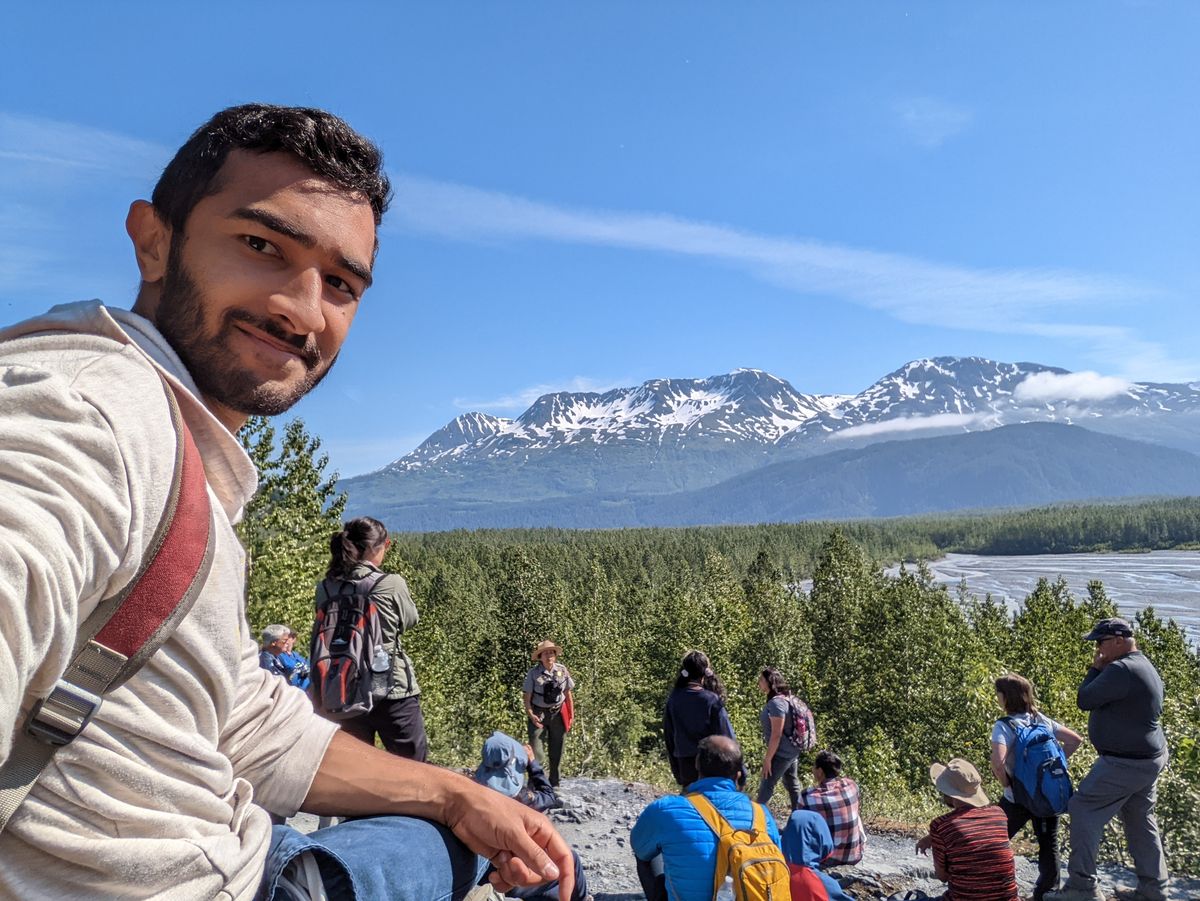Group of hikers with snow-capped Alaska mountains behind them
