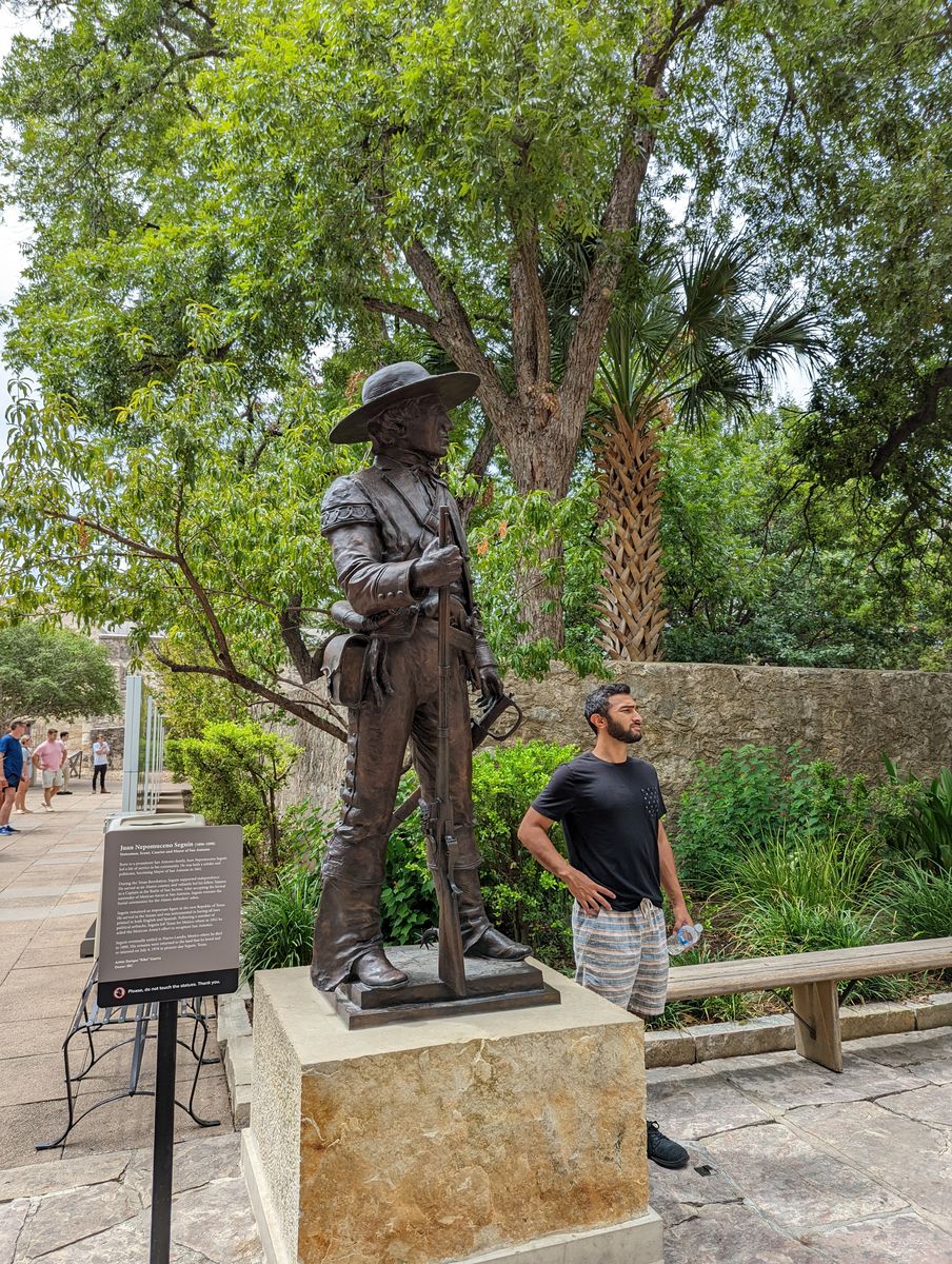 Mufaddal posing by the bronze Texas Ranger statue at the Alamo