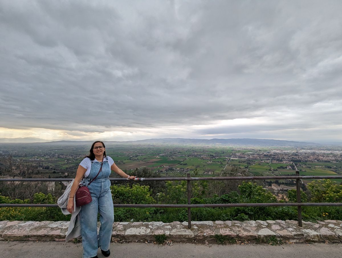 Woman in denim overalls overlooking the Umbrian valley