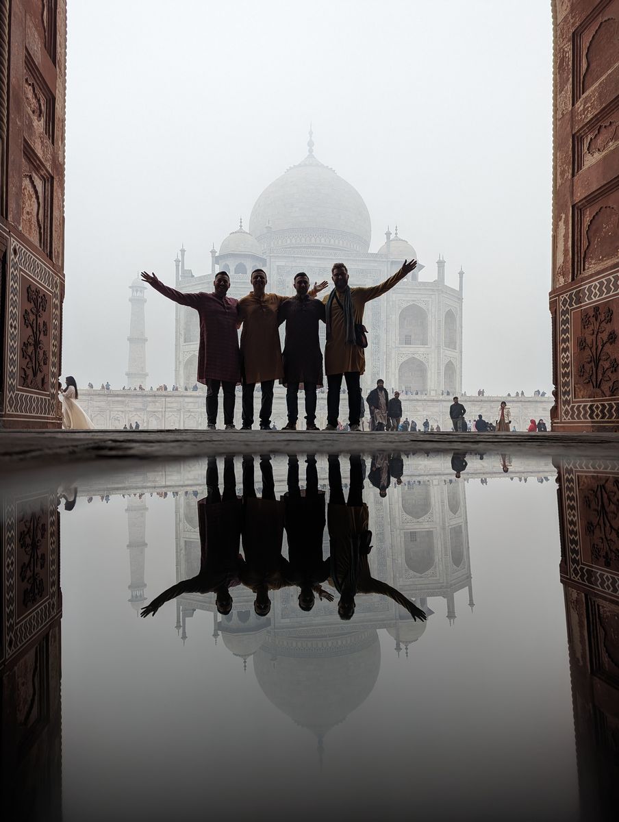 Four men in traditional attire before the Taj Mahal