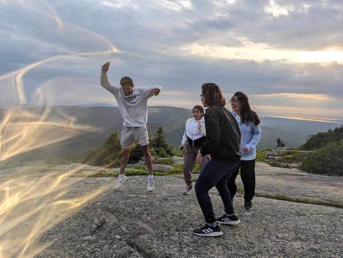 Friends on a rocky mountaintop at sunset